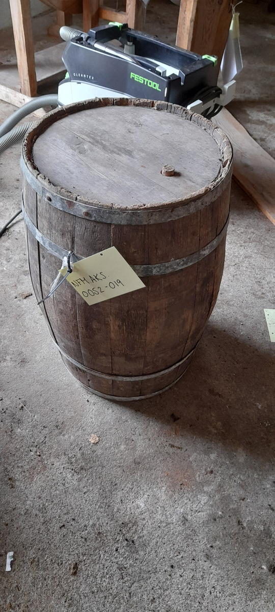 Tønne. Innsett botn og topp. Hol med treplugg i topp. Hol i sida. Fire metall band.