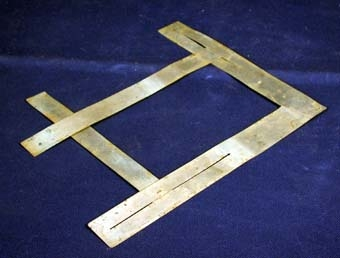 Remsor av tunn plåt bildar en rektangulär ram genom att två remsor sitter ihop vinkel. I dessa är två andra remsor fästade i utskurna spår. Eftersom dessa remsor är fästade i spår kan de flyttas  upp och ned vilket gör att ramen kan bli olika stor.