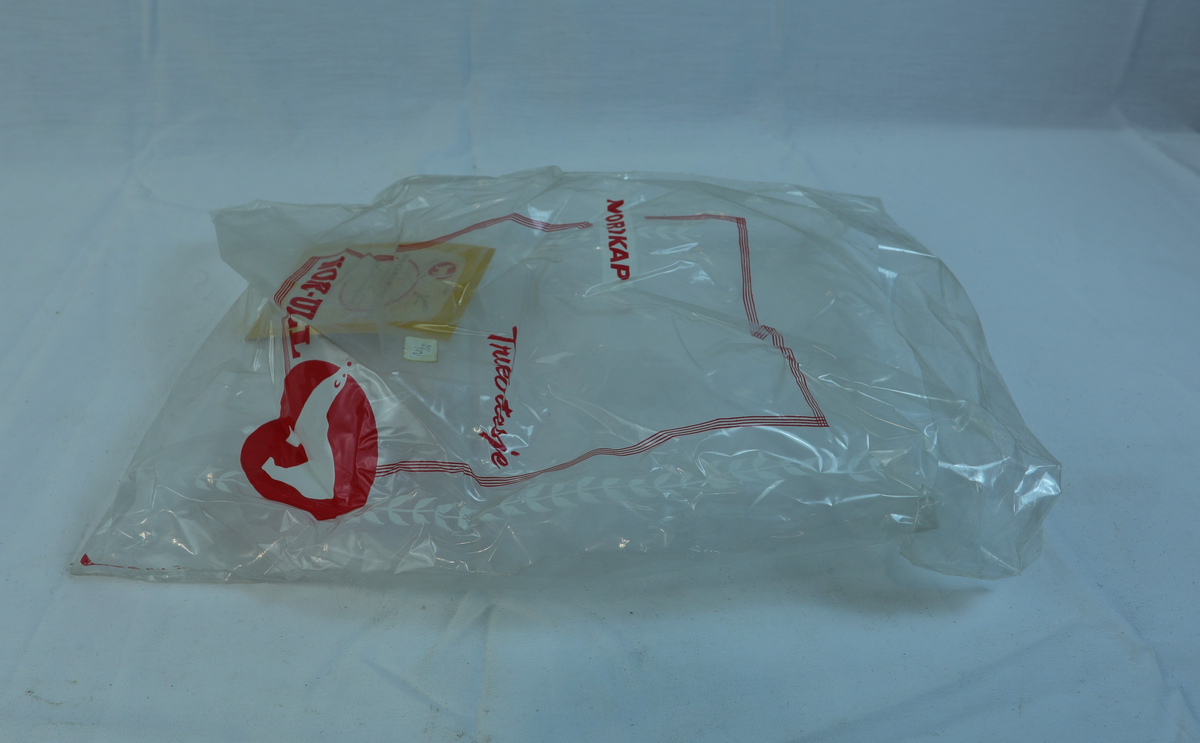 Plastpose/plastemballasje som klær har ligget ut. En papplapp i posen. 