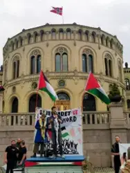 Demonstrasjon foran Stortinget med krav om at politikerne skal stemme for å trekke oljefondet ut av Israels økonomi, 4. juni 2025. På scenen: Line Khateeb fra Palestinakomiteen og Bjørnar Moxnes fra partiet Rødt.
