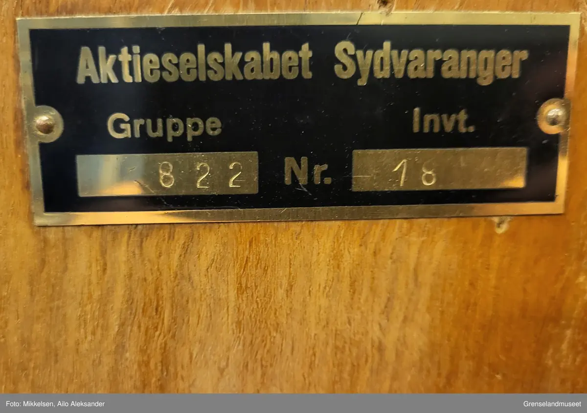 Gjenstanden er et brunt Abeco skap av tre med låsbar skyvedør. Skapet har fjorten hyller med midtskille til oppbevaring av stein- og mineralprøver. Gjenstanden har vært i bruk over lang tid noe som har har ført til at skapet har blitt nedslitt. Den brune trefargen arge er nedslitt på flere steder. Bortsett fra å bære preg aldertidsbruk har skapet har ingen betydelige skader. Nøkkelen til skapet mangler.  