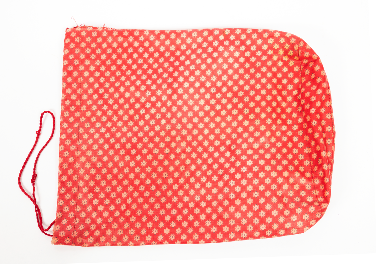 Blommig säck av galontyg innehållande badkläder: rutig bikini, blå badbyxor och blå/rosa bikinibyxor. Medföljde vid insamlingen av Vegkryssaren TERTIA.