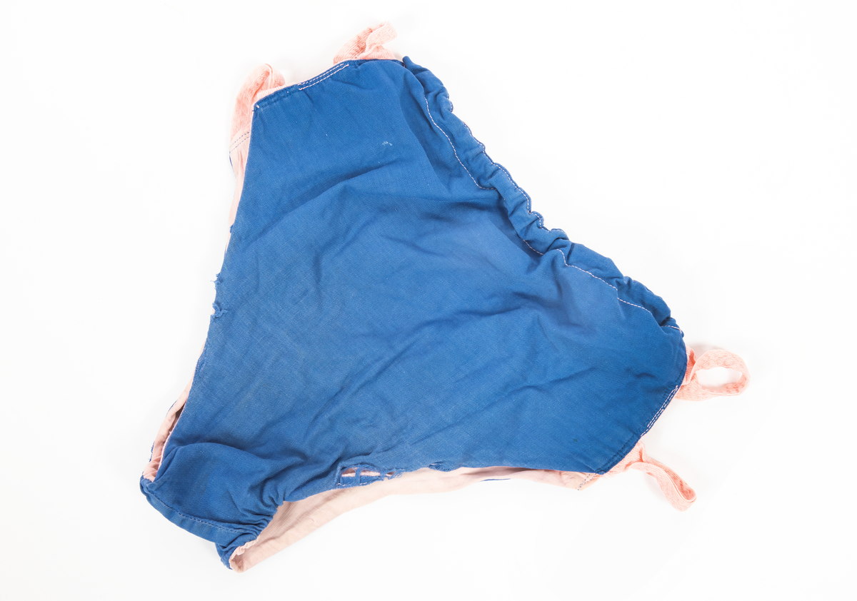 Blommig säck av galontyg innehållande badkläder: rutig bikini, blå badbyxor och blå/rosa bikinibyxor. Medföljde vid insamlingen av Vegkryssaren TERTIA.