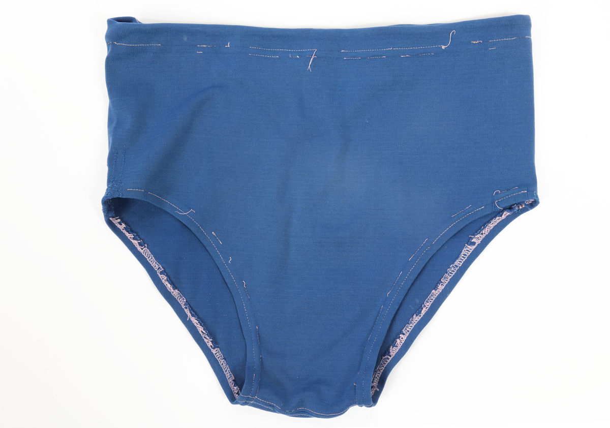 Blommig säck av galontyg innehållande badkläder: rutig bikini, blå badbyxor och blå/rosa bikinibyxor. Medföljde vid insamlingen av Vegkryssaren TERTIA.