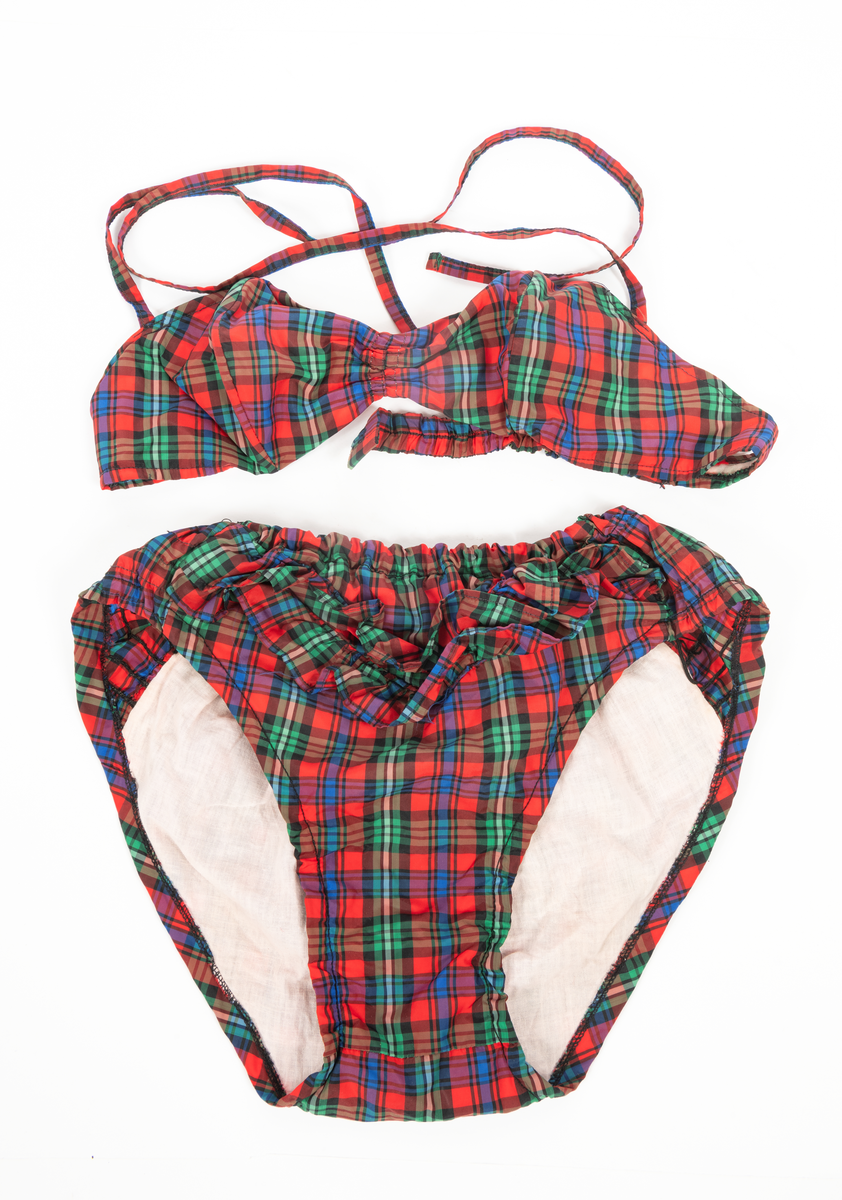 Blommig säck av galontyg innehållande badkläder: rutig bikini, blå badbyxor och blå/rosa bikinibyxor. Medföljde vid insamlingen av Vegkryssaren TERTIA.