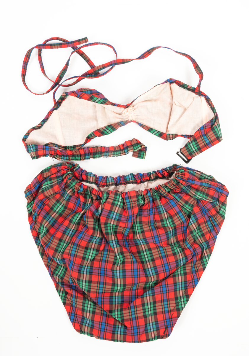 Blommig säck av galontyg innehållande badkläder: rutig bikini, blå badbyxor och blå/rosa bikinibyxor. Medföljde vid insamlingen av Vegkryssaren TERTIA.