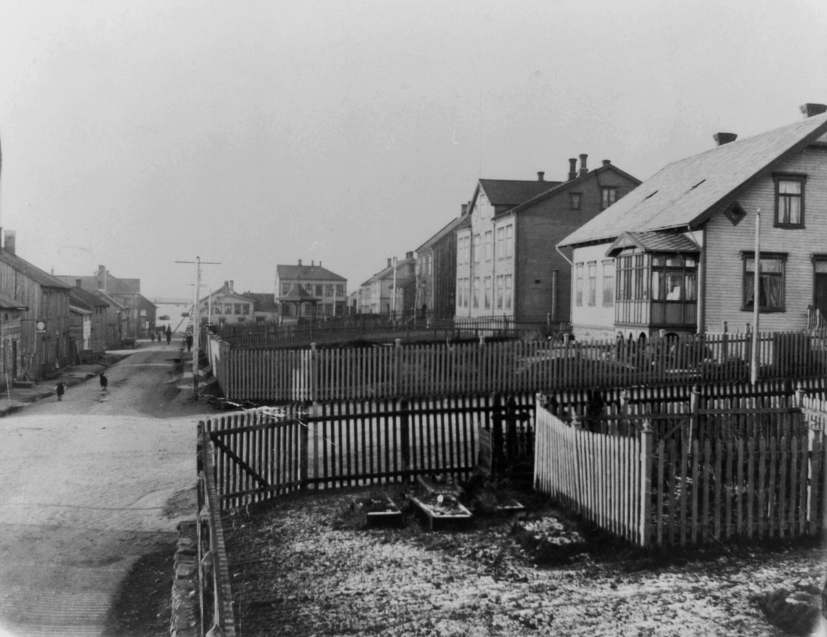 Gateparti fra Vadsø på 1930-tallet. Ved venstre side to geiter løper langs gata, i midt på bildet ligger musikkpaviljongen. 