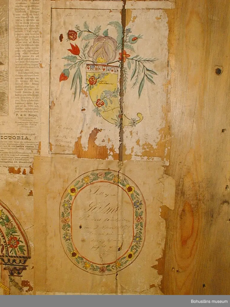 Väggen består av tio brädor, säkrade vid nedtagningen på baksidan med två tvärgående samt en diagonal planka. Vid gåvotillfället delades väggen i två för att kunna bäras ner för den smala vindstrappan.
Rader med äldre nubb samt papprester sitter jämnt fördelade över framsidan. Kan vara rester av ett sekundärt väggfält som placerats över det befintliga för 50-100 år sedan.
Tjugotvå minnestavlor är klistrade längs vänstra och högra kanten samt som en korsliknande form på mitten. Däremellan är sex tidningssidor från "Morgonbladet" (landsortsupplagan) år 1890 samt tio fragment från tidningar uppsatta. Det finns också två tryckta blad med "varningsord" från år 1888 samt fyra blad från "Arbetarens Vän", 1880-talet. Tre kartor från ca 1884 över Canadian Pacific Railway, Manitoba och Nordvesten sitter överst i mitten.
De flesta minnestavlorna är tillägnade Se(ä)lma Kin(d)gren på födelsedagen den 9 april åren 1868-1871. Två är tillägnade Carl på hans namnsdagar 28 januari åren 1868 och 1869.
Pappret har gulnat med tiden. Ett flertal rejäla skadedjursangrepp på framförallt minnestavlorna. 

Väggens baksida har fyra blad av "Morgonbladet"s första sida från år 1890 samt två fragment. På två av första sidorna står "AG. Sellberg, Lycke" skrivet med blyerts.
Se bilaga i Bilagepärmen.