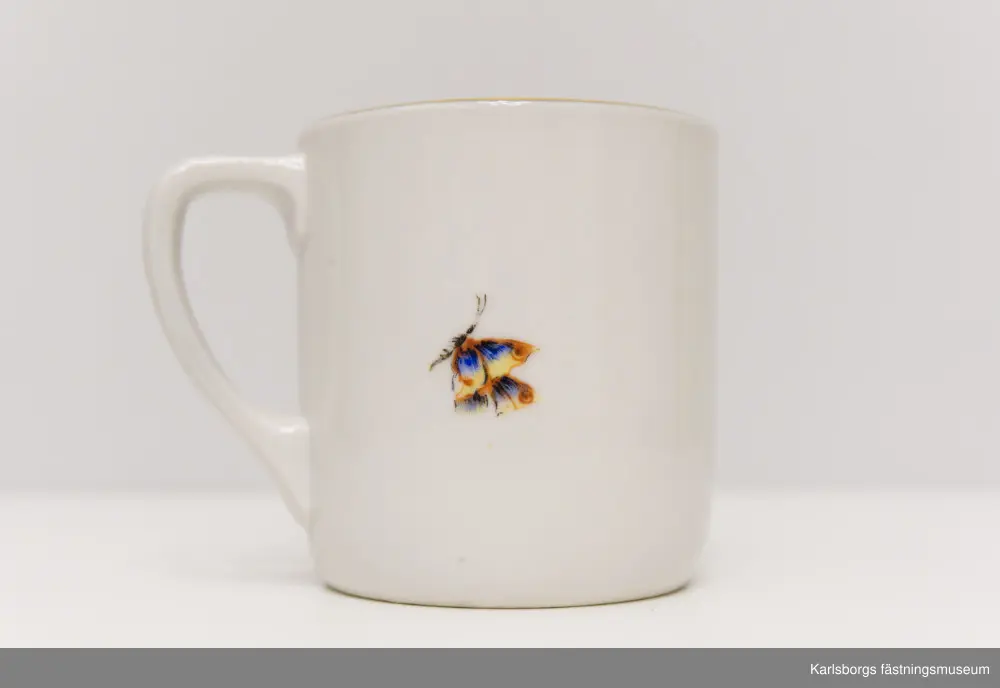 Kaffekopp med barnmotiv och fjäril. Guldmönstrad kantbård. Märkt på undersidan av tillverkarna men är svårläst.