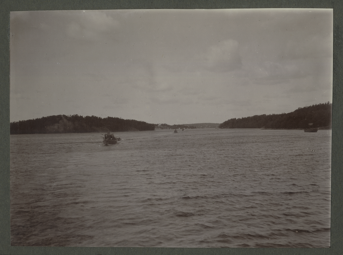 Bogseringsbåt till sjöss med småbåtar i fjärran. I bakgrunden syns Ramsö.