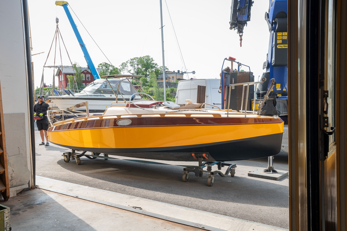 Ruffad segelkanot i plywood. Osänkbar och självlänsande. Gulmålat skrov, vinröd dekor.