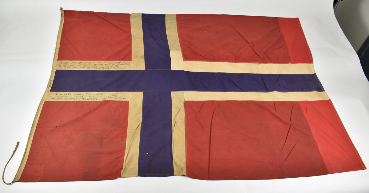 Norskt flagg som har påsydd nytt raudt stoff på enden.