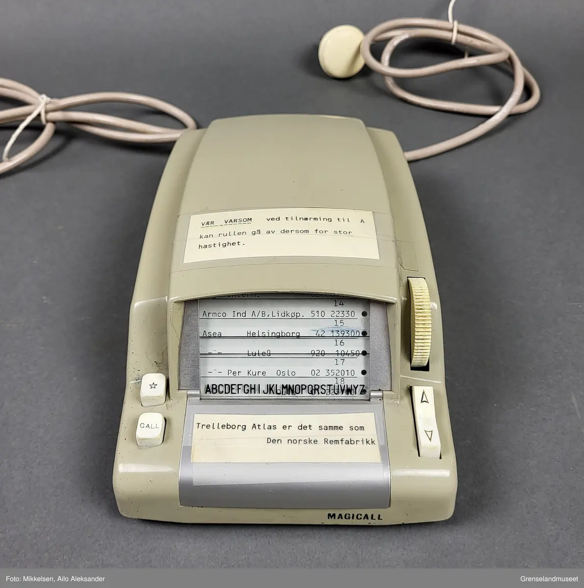 Gjenstanden er en Magicall Electronic Dialer laget av det amerikanske selskapet Dasa Corporation med tilhold i Andover Massachusetts. Gjenstandens form er rektangulør med en liten skjerm med plass til fem linjer med navn, adresse og telefonnummer. Den oppereres ved hjelp av tre knapper og en hjulformet scroller. På forsiden av gjenstanden står det i store bokstaver på svartskrift "MAGICALL". 

Gjenstanden var ment til å brukes oppkoblet mot eldre dreieskivetelefoner. Den fungerte ved at opperatøren kunne utføre en automatisk oppringning av nummerene som på forhånd hadde blitt manuelt innprogrammert på den. Ved å scrolle ned eller opp ved hjelp av piltastene kunne opperatøren bruke enkelte tastetrykk for å finne riktig nummer. Ved hjelp av hjullet ovenfor piltaststknappen kunne opperatøren kjapt scrolle igjennom listen i begge retninger. "Stjerne" knappen ble brukt til å bekrefte det spesikke nummeret som skulle ringes og "Call" knappen ble brukt til å iverksette den automatiske oppriningen.

Det er påklistret to merker ovenfor og nedenfor skjermen. På merket over skjermen står det: "Vær varsom ved tilnærming til A kan rullen gå av dersom for stor hastighet." 
På merket nedenfor står det: "Trelleborg Atlas er der samme som Den norske Remfabrikk". 

På undersiden av gjenstanden er det et lokk som kan skrues av for å bytte rull. Fabrikatt stemplet til gjenstanden er også lokalisert på undersiden av gjenstanden. På den står det: "CAUTION UNPLUG 120V AC BEFORE REMOVING HOUSING." "MAGICALL (R) ELECTRONIC DIALLER MODEL E-2. MADE IN USA BY DASA CORPORATION ANDOVER MASACHUSSETS. PAT. PEND. SERIAL NO 39983."   

Gjenstanden har to stikkkontakter. Den første ledningen har en stikkontakt som plasseres i et telfontuttak. Den andre ledningen går til en strømomformer som selv har en egen stikkkontakt som plasseres i et strømuttak. Strømomformeren er rektangulær og har 47 ventilasjonshull på hver sin side, og har 63 ventilasjonshull på øversiden. På baksiden har den fire hekter hvor det er meningen at den skal festes til en vegg. På produksjosstemplet er serienummeret "371371", og "230V- 50P/S 0,75A". På høyrse side står det: "Code KED 90101 22 V 50 Hz - 40 W".   



