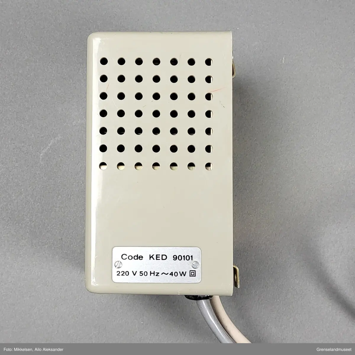 Gjenstanden er en Magicall Electronic Dialer laget av det amerikanske selskapet Dasa Corporation med tilhold i Andover Massachusetts. Gjenstandens form er rektangulør med en liten skjerm med plass til fem linjer med navn, adresse og telefonnummer. Den oppereres ved hjelp av tre knapper og en hjulformet scroller. På forsiden av gjenstanden står det i store bokstaver på svartskrift "MAGICALL". 

Gjenstanden var ment til å brukes oppkoblet mot eldre dreieskivetelefoner. Den fungerte ved at opperatøren kunne utføre en automatisk oppringning av nummerene som på forhånd hadde blitt manuelt innprogrammert på den. Ved å scrolle ned eller opp ved hjelp av piltastene kunne opperatøren bruke enkelte tastetrykk for å finne riktig nummer. Ved hjelp av hjullet ovenfor piltaststknappen kunne opperatøren kjapt scrolle igjennom listen i begge retninger. "Stjerne" knappen ble brukt til å bekrefte det spesikke nummeret som skulle ringes og "Call" knappen ble brukt til å iverksette den automatiske oppriningen.

Det er påklistret to merker ovenfor og nedenfor skjermen. På merket over skjermen står det: "Vær varsom ved tilnærming til A kan rullen gå av dersom for stor hastighet." 
På merket nedenfor står det: "Trelleborg Atlas er der samme som Den norske Remfabrikk". 

På undersiden av gjenstanden er det et lokk som kan skrues av for å bytte rull. Fabrikatt stemplet til gjenstanden er også lokalisert på undersiden av gjenstanden. På den står det: "CAUTION UNPLUG 120V AC BEFORE REMOVING HOUSING." "MAGICALL (R) ELECTRONIC DIALLER MODEL E-2. MADE IN USA BY DASA CORPORATION ANDOVER MASACHUSSETS. PAT. PEND. SERIAL NO 39983."   

Gjenstanden har to stikkkontakter. Den første ledningen har en stikkontakt som plasseres i et telfontuttak. Den andre ledningen går til en strømomformer som selv har en egen stikkkontakt som plasseres i et strømuttak. Strømomformeren er rektangulær og har 47 ventilasjonshull på hver sin side, og har 63 ventilasjonshull på øversiden. På baksiden har den fire hekter hvor det er meningen at den skal festes til en vegg. På produksjosstemplet er serienummeret "371371", og "230V- 50P/S 0,75A". På høyrse side står det: "Code KED 90101 22 V 50 Hz - 40 W".   



