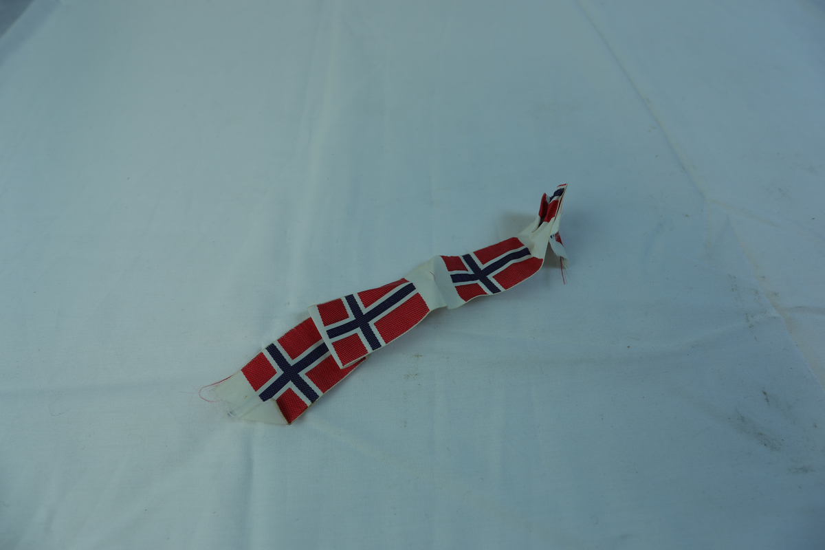 Remse i tekstil med fire norske flagg.