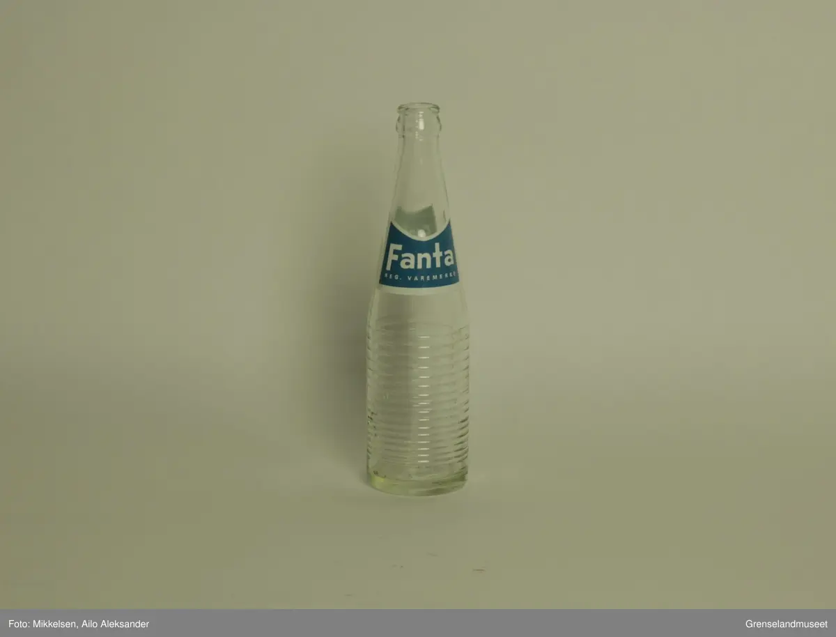Gjenstanden er en brusflasker i glass med logo og varemerke til Fanta reg. varemerke. Flasken er hel og i god stand. Merkelappen er i god stand og viser bare tegn til å ha stått lagret over lengre tid. 