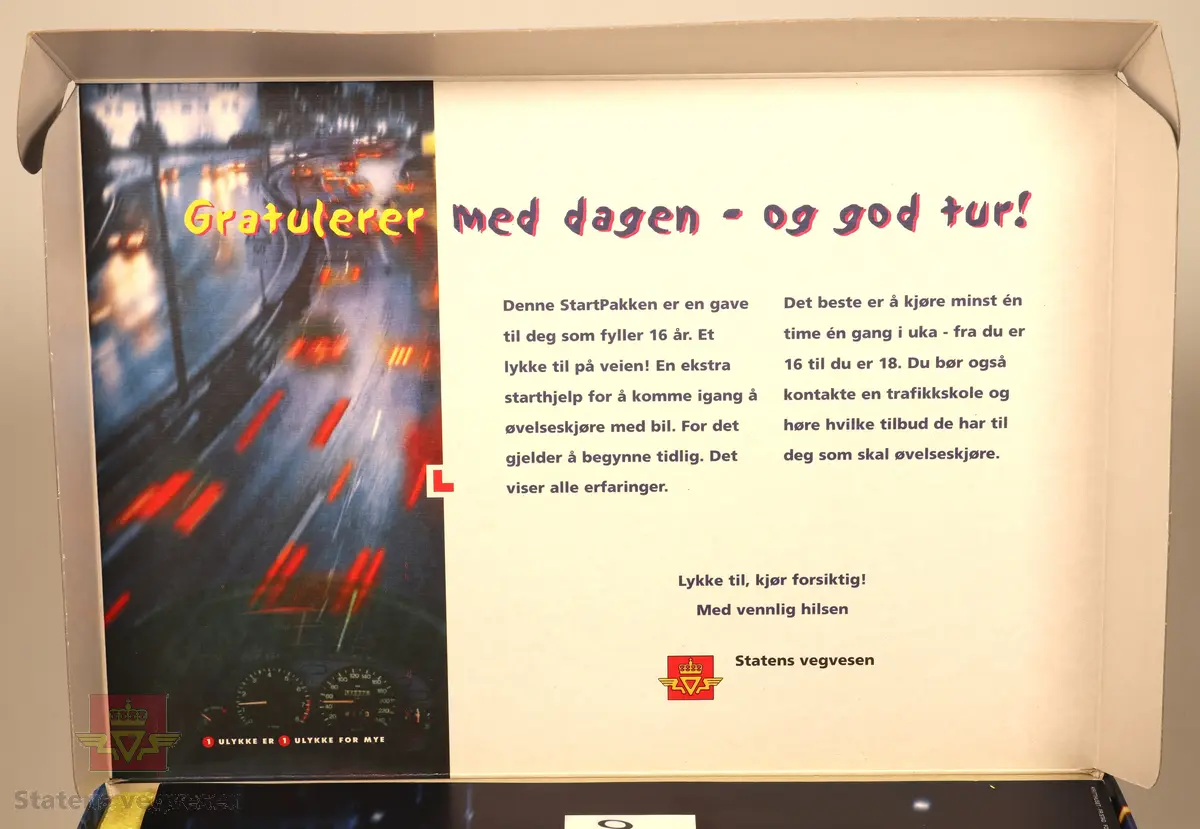 Pappeske som innholder opplæringsmateriell:
-Kjørebok
-Guide for øvelseskjøring
-Timeplan
-Video og CD
-"L" for å sette bak på bil
-Ekstra speil for passasjer/ledsager