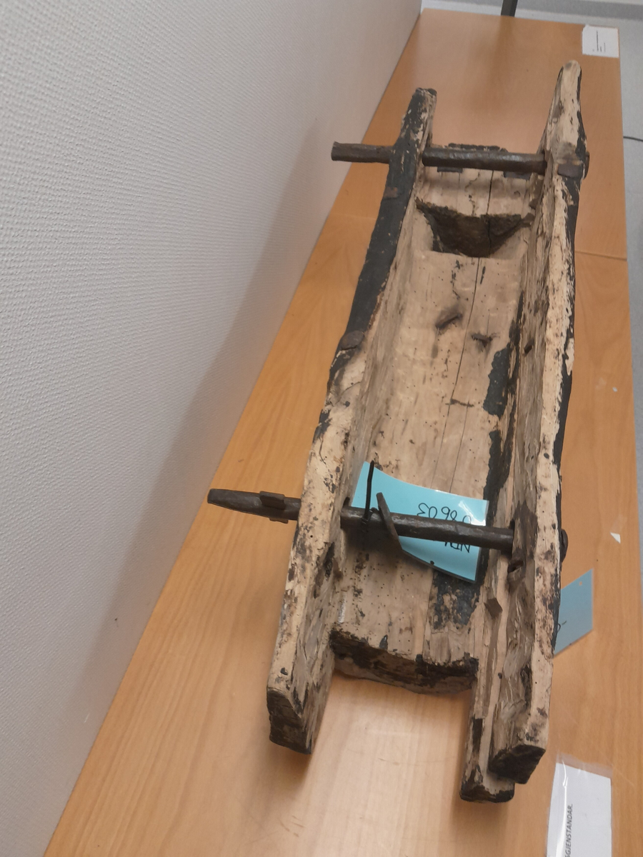 Renne i tre. Utholing truleg øksa ut.  Bolt i jarn gjennom to parallelle hol i sidene, oppe og nede. Boltane kan løysast og låsast. Jarn klammer og bolter (firekanta og runde hovud) er slått inn fleire stader i treet. Rektangulært hol i treet opp mot eine bolten. Områder med svart, truleg tjære.

Kan ha vore brukt på Holvikejekta som vern på baugen.