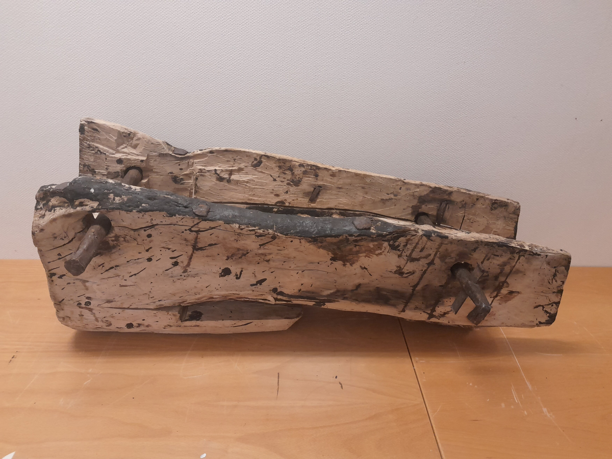 Renne i tre. Utholing truleg øksa ut.  Bolt i jarn gjennom to parallelle hol i sidene, oppe og nede. Boltane kan løysast og låsast. Jarn klammer og bolter (firekanta og runde hovud) er slått inn fleire stader i treet. Rektangulært hol i treet opp mot eine bolten. Områder med svart, truleg tjære.

Kan ha vore brukt på Holvikejekta som vern på baugen.