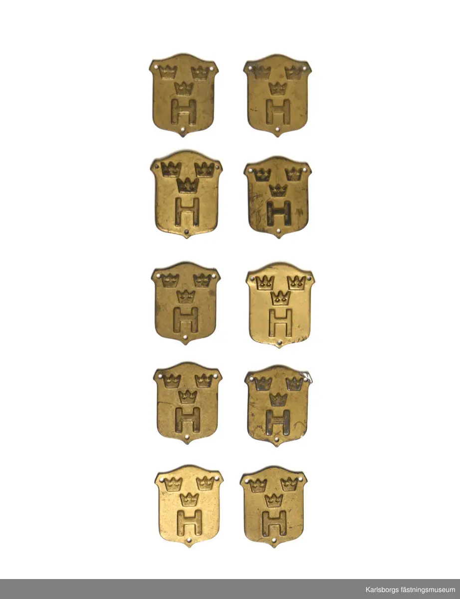 Tio stycken utmärkelsetecken m/1946-60 i guldfärg för hemvärnet. Monteras på uniform med tråd. 23 x 27 mm.