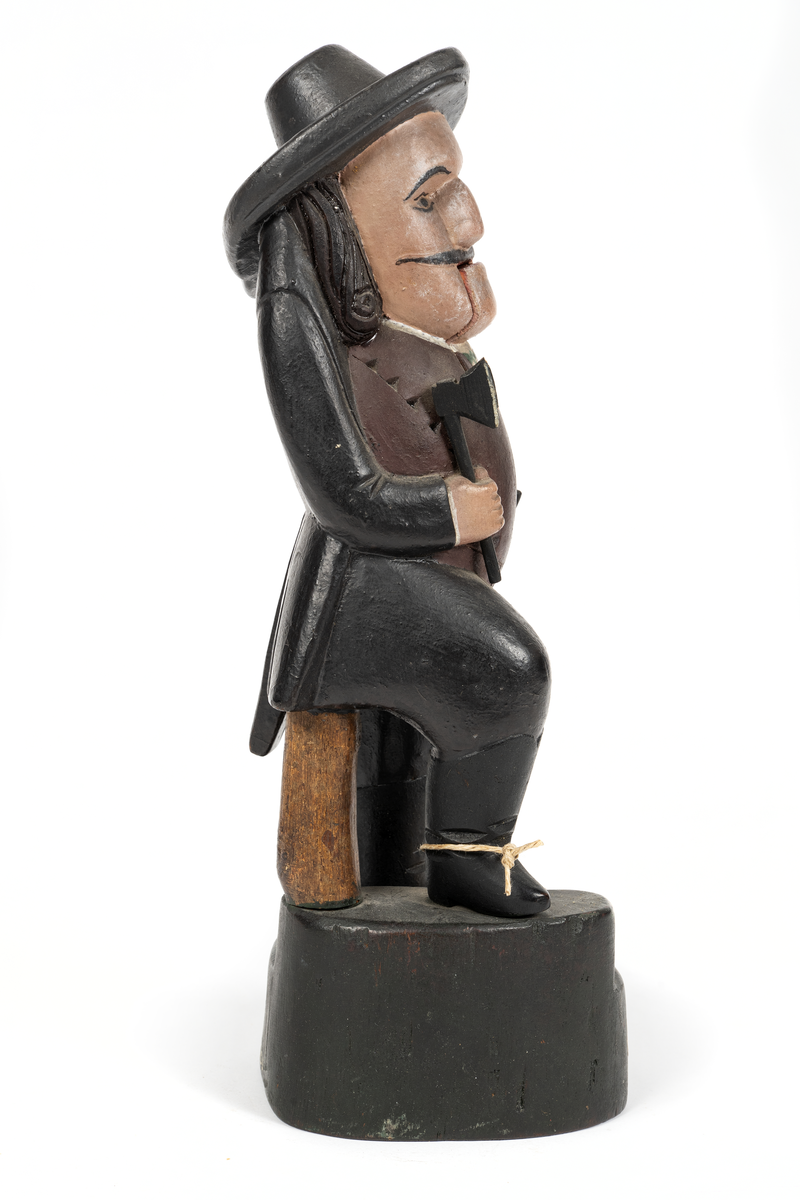 Träskulptur, (ungersk?) jägare med ledbar haka. I högra handen yxa, i vänstra bössa med avbruten kolv.