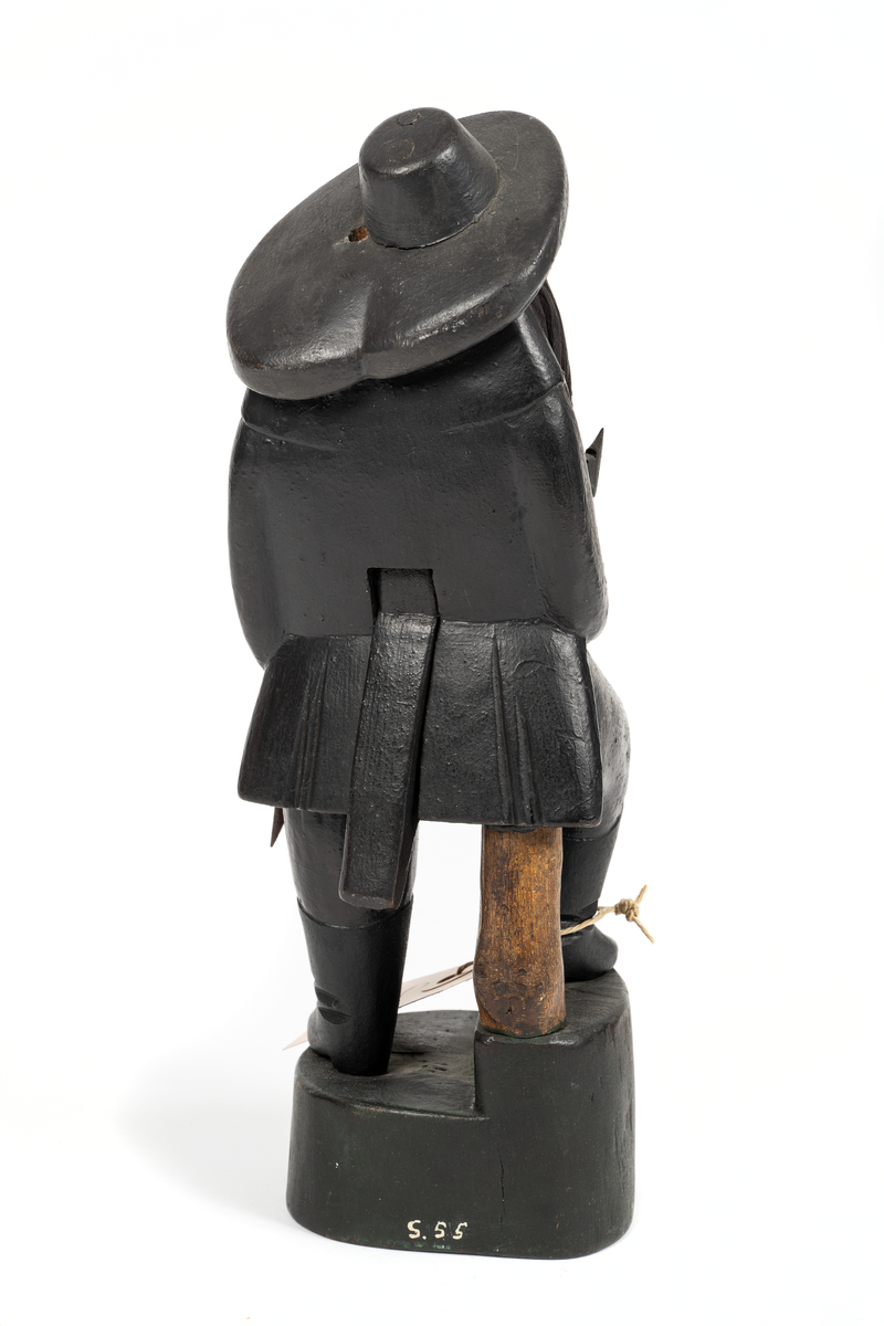 Träskulptur, (ungersk?) jägare med ledbar haka. I högra handen yxa, i vänstra bössa med avbruten kolv.