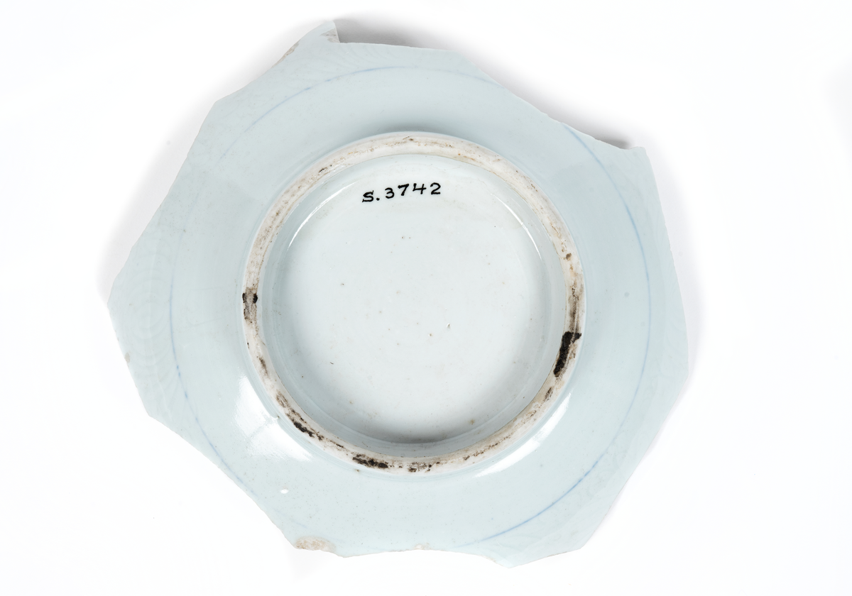 Fragment (skärvor) av ostindiskt porslin, vit botten, blå och brun dekor. Antal bitar= 111 st.