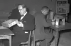 Hantverkstävling på Rotundan den 2 april 1950. Män synar trälådor.