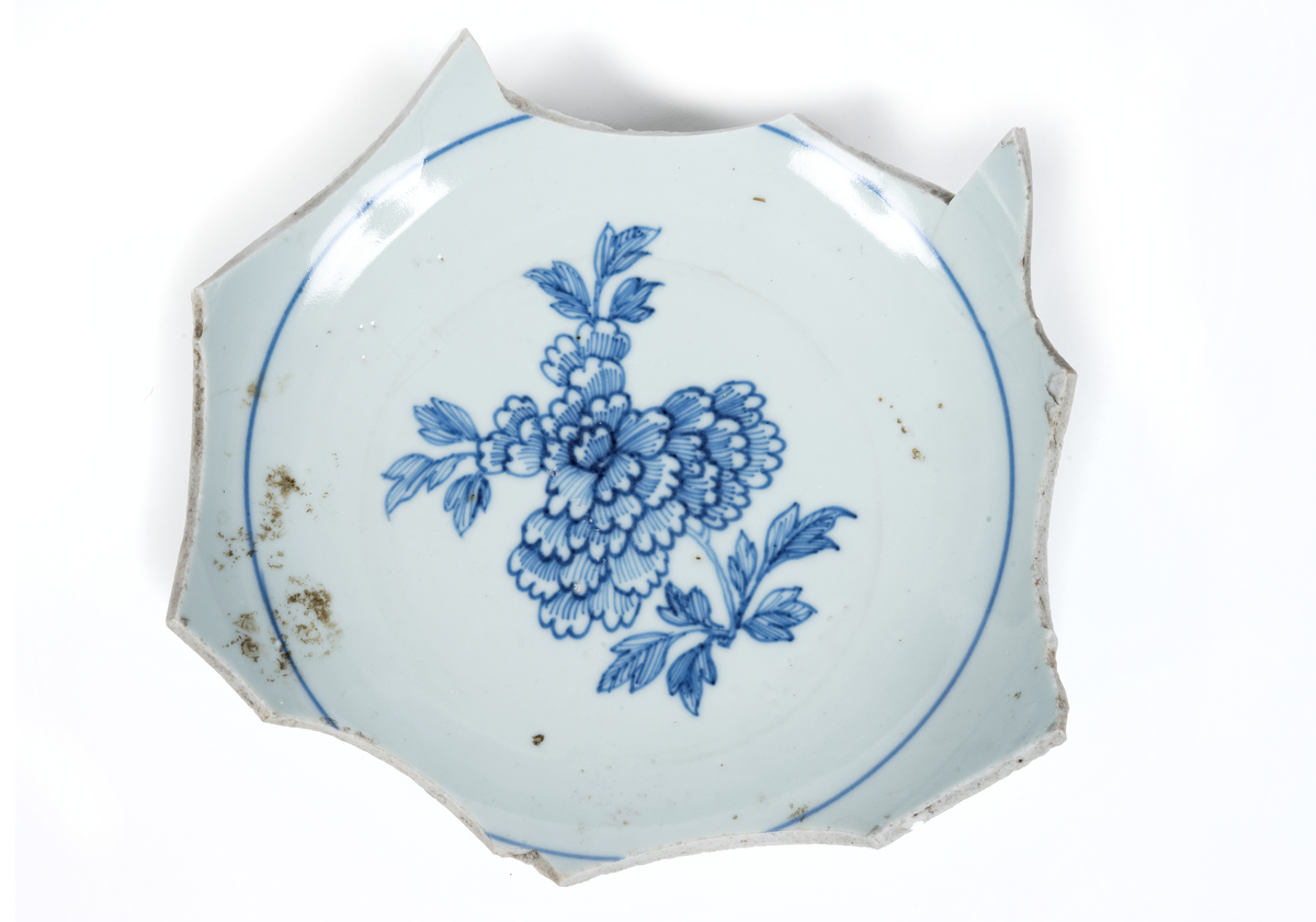 Fragment (skärvor) av ostindiskt porslin, vit botten, blå och brun dekor. Antal bitar= 111 st.