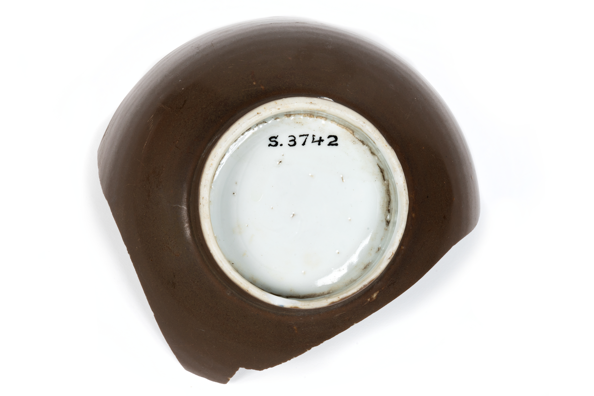 Fragment (skärvor) av ostindiskt porslin, vit botten, blå och brun dekor. Antal bitar= 111 st.