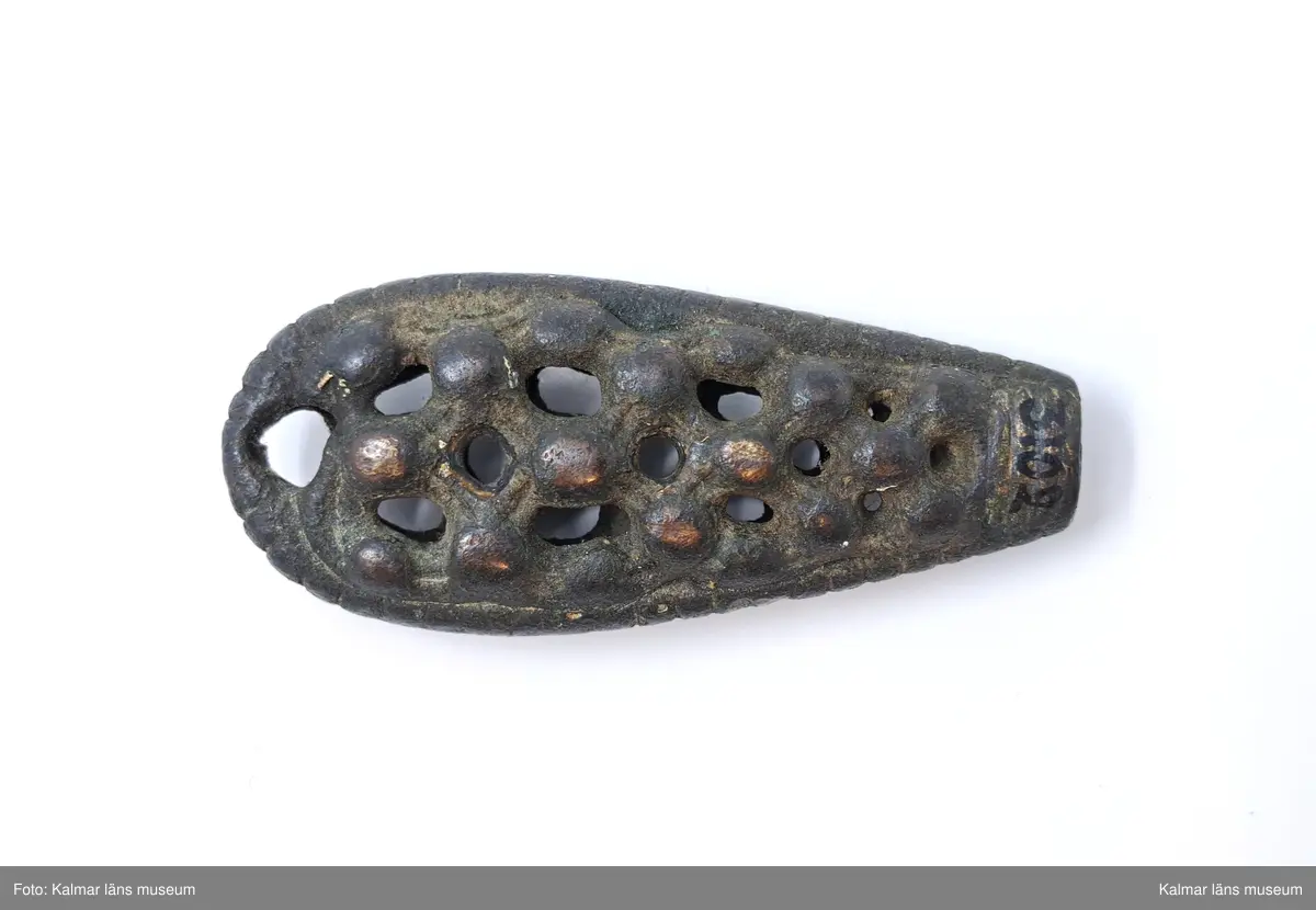 KLM 3102. Nyckel, nyckelskaft. Gjutet av brons. Handtaget är kraftigt spolformigt med genombruten ornamentik med knoppar. På sidorna tvärräfflad. Själva axet saknas.