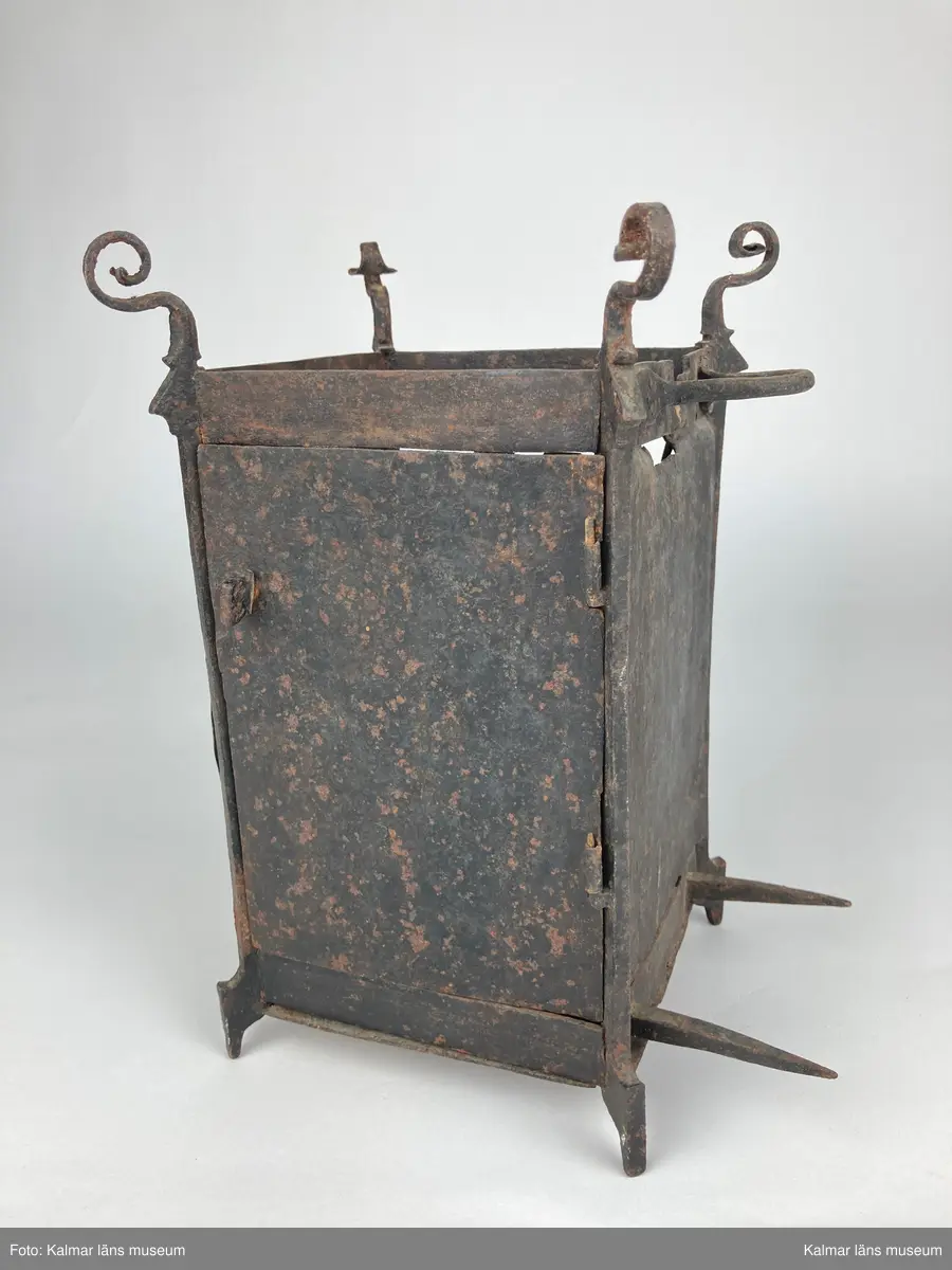 KLM 46893. Bordsur. Rektangulär stomme av järn med öppningsbara sidor, varav ena sidans dörr saknas. Upptill smidda detaljer. På ena sidan urtavla av mässing med stjärna i mitten, en visare av järn. Bakom urtavlan ett blekt pappersark i blågrönt. Urverk av järn och mässing. Uret har fyra fötter. På baksidan ögla av järn. Pendel, lodlinor, lod och trissor saknas.