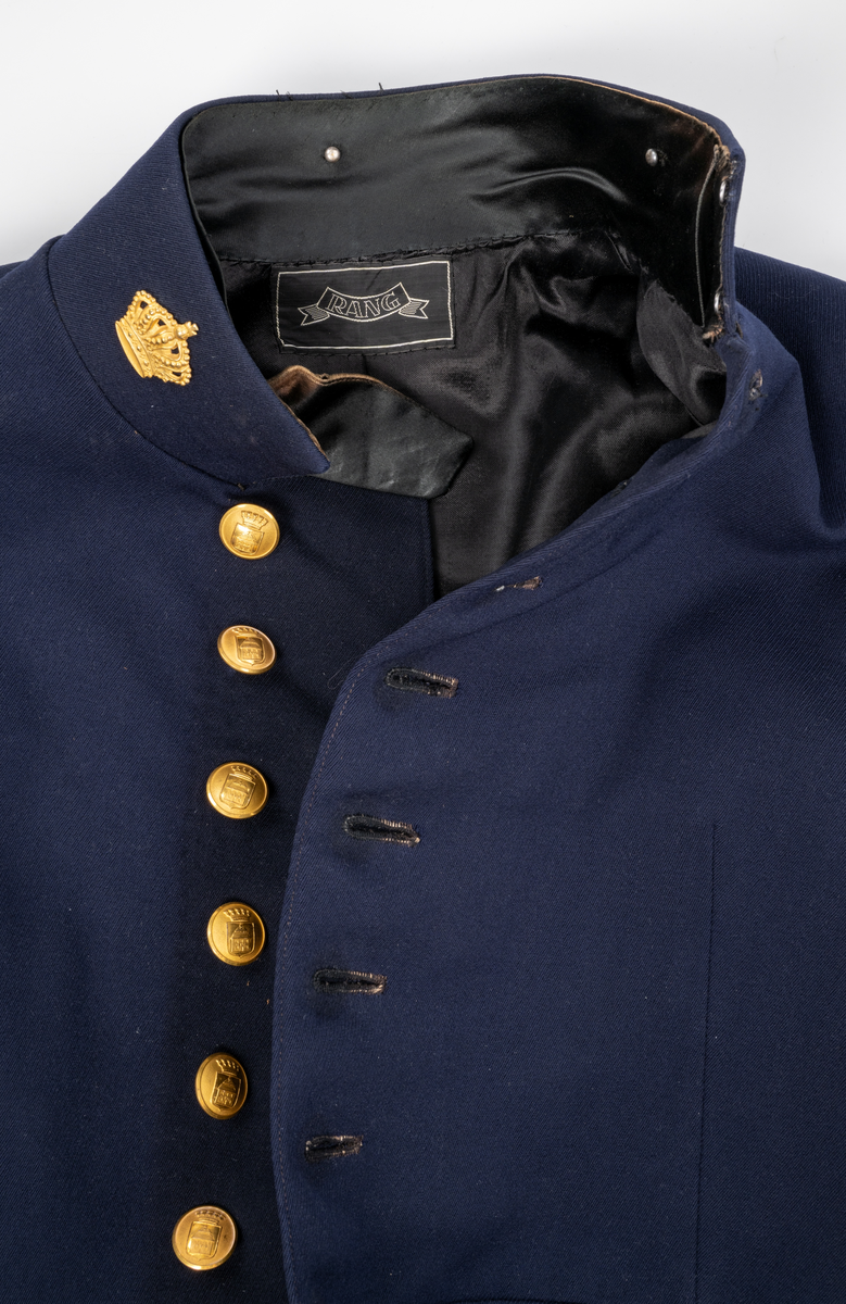 Uniformsjacka. Mörkblå. Enkel knäppning framtill med åtta knappar. På nedre delen av ärmarna tre mindre knappar. Sprund baktill med sex knappar. Alla uniformsknappar förgyllda och präglade med Växjö stadsvapen (år 1926-39). Kragmärke på var sida av ståndkragen, en förgylld kunglig krona med kudde.