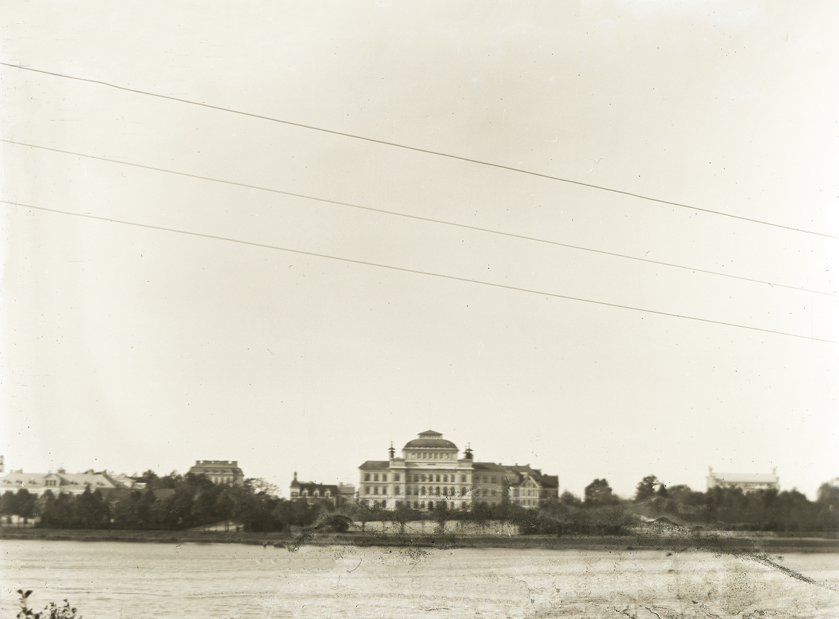 Vy över Växjösjön, med Växjö Högre Allmänna  Läroverk i mitten. 
Till vänster skymtar bl a dåv. Flickskolan och till höger skymtar Smålands museums byggnad.
Något suddigt foto.