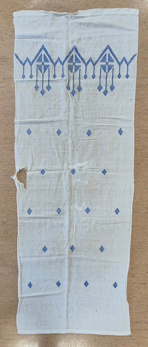 Gardin vävt i vit med blå inslag.