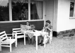 Storvik-Hammarby. Kvinnor sitter ute och läser Gefle Dagblad