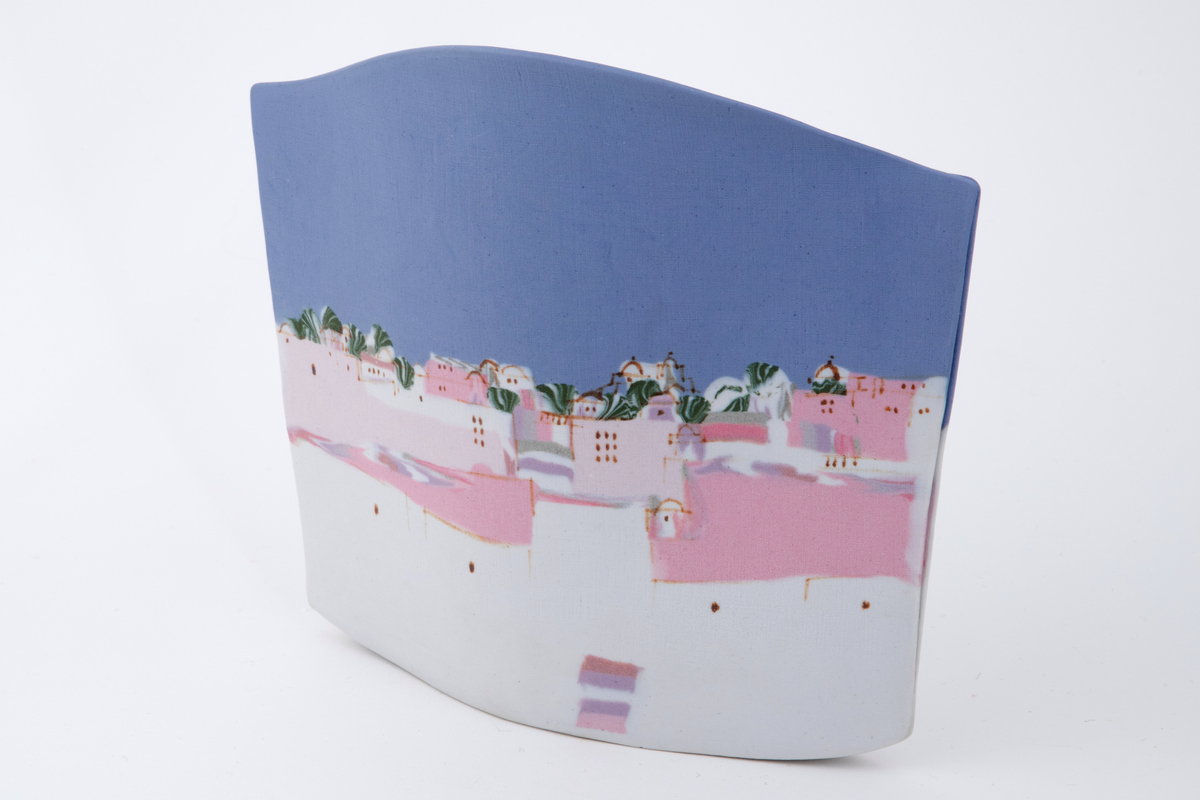 Flat vase sammensatt av to porselensflater. Den ene flaten er konveks oventil mens den andre er konkav. Begge flater prydes på inn- og utside av motiv i blått, hvit, rosa og grønt forestillende et bylandskap. Motivet er skapt med hjelp av innfarget porselen.