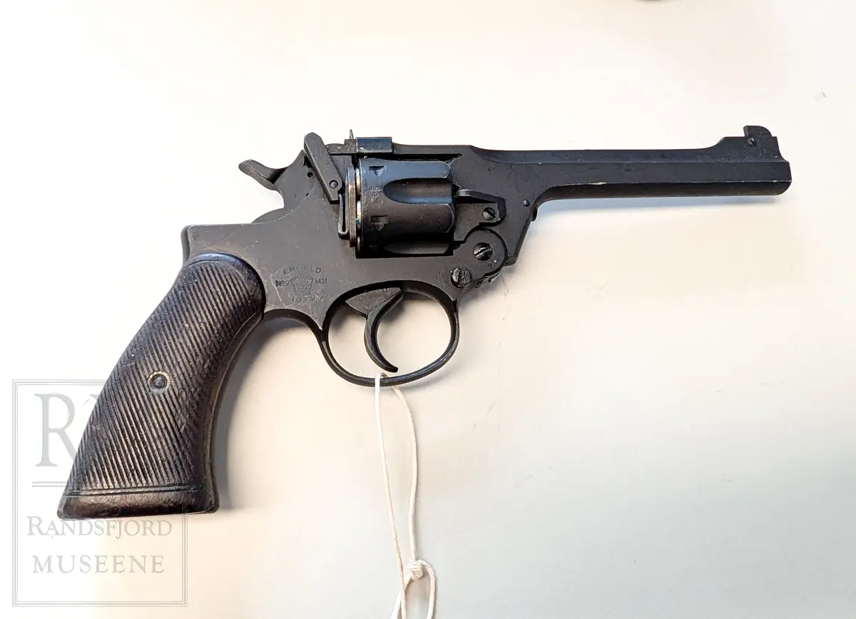 Svart metall. Hylster m belte i kakifarget lerret. Kaliber 38 ACP.