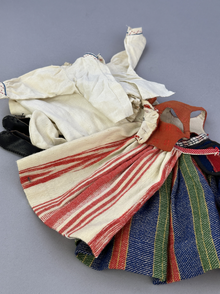 Sockendräkts kläder i 9 delar -  föreställande den kvinnliga dräkten från Östervallskogs socken i Värmland. Docka saknas.