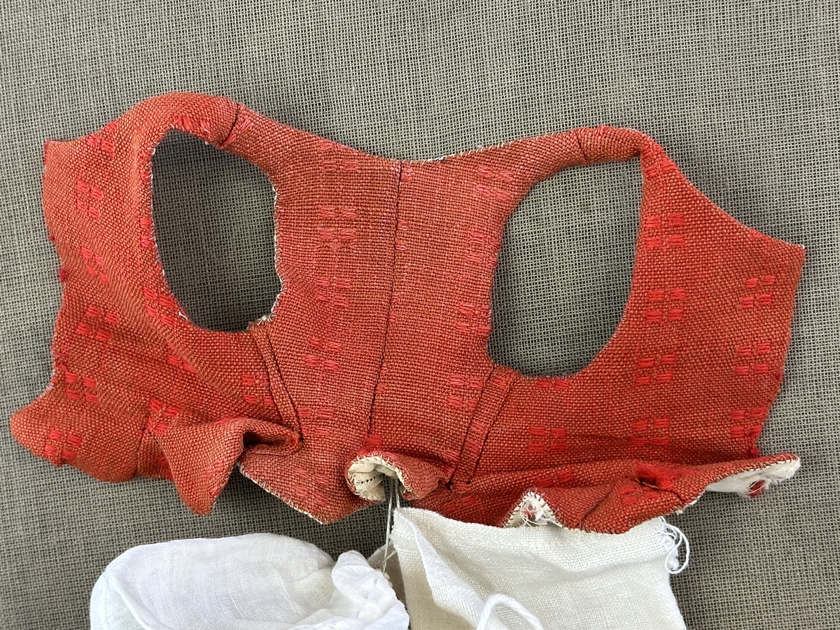 Sockendräkts kläder i 9 delar -  föreställande den kvinnliga dräkten från Östervallskogs socken i Värmland. Docka saknas.