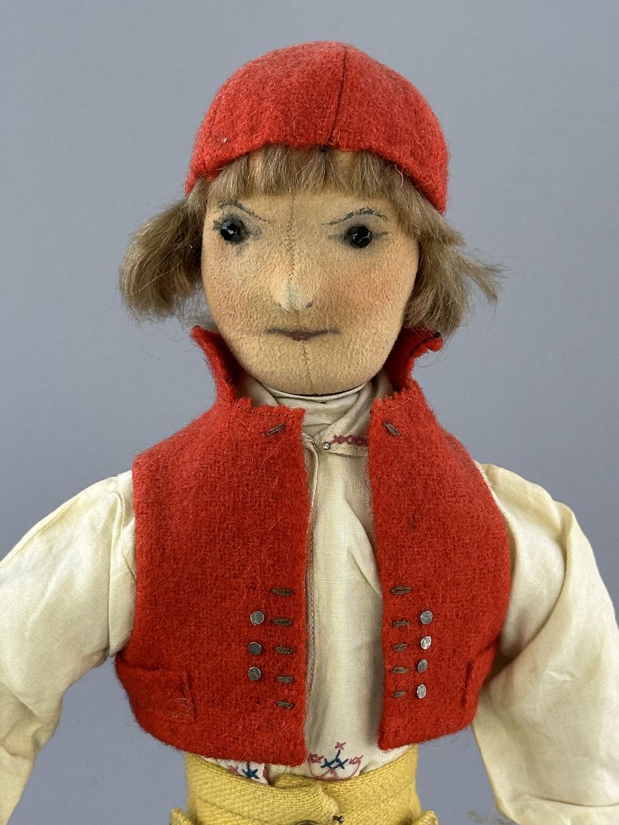 Docka klädd i manlig sockendräkt föreställande Norra Ny socken i Värmland. Huvud och händer sydda av sämskskinn samt kropp av trikåtyg.