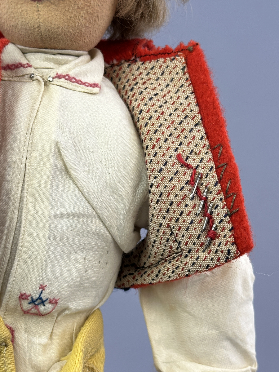 Docka klädd i manlig sockendräkt föreställande Norra Ny socken i Värmland. Huvud och händer sydda av sämskskinn samt kropp av trikåtyg.