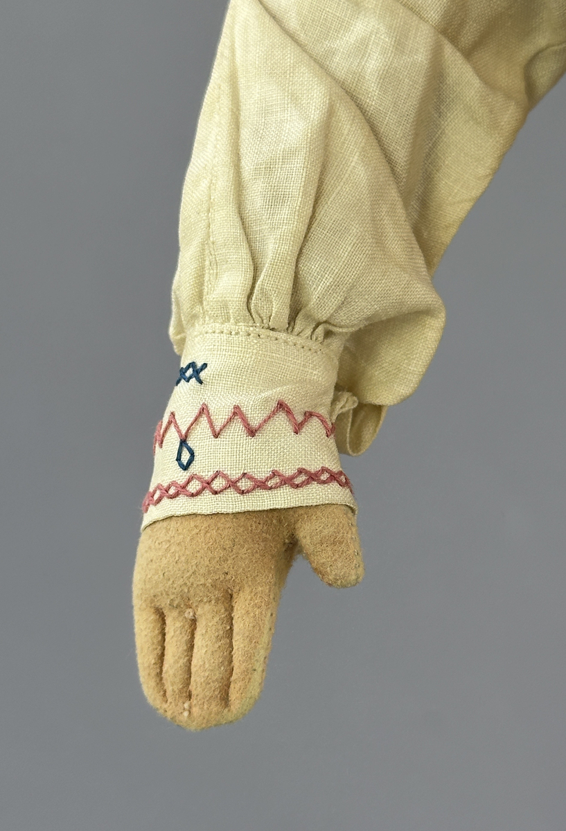 Docka klädd i manlig sockendräkt föreställande Norra Ny socken i Värmland. Huvud och händer sydda av sämskskinn samt kropp av trikåtyg.