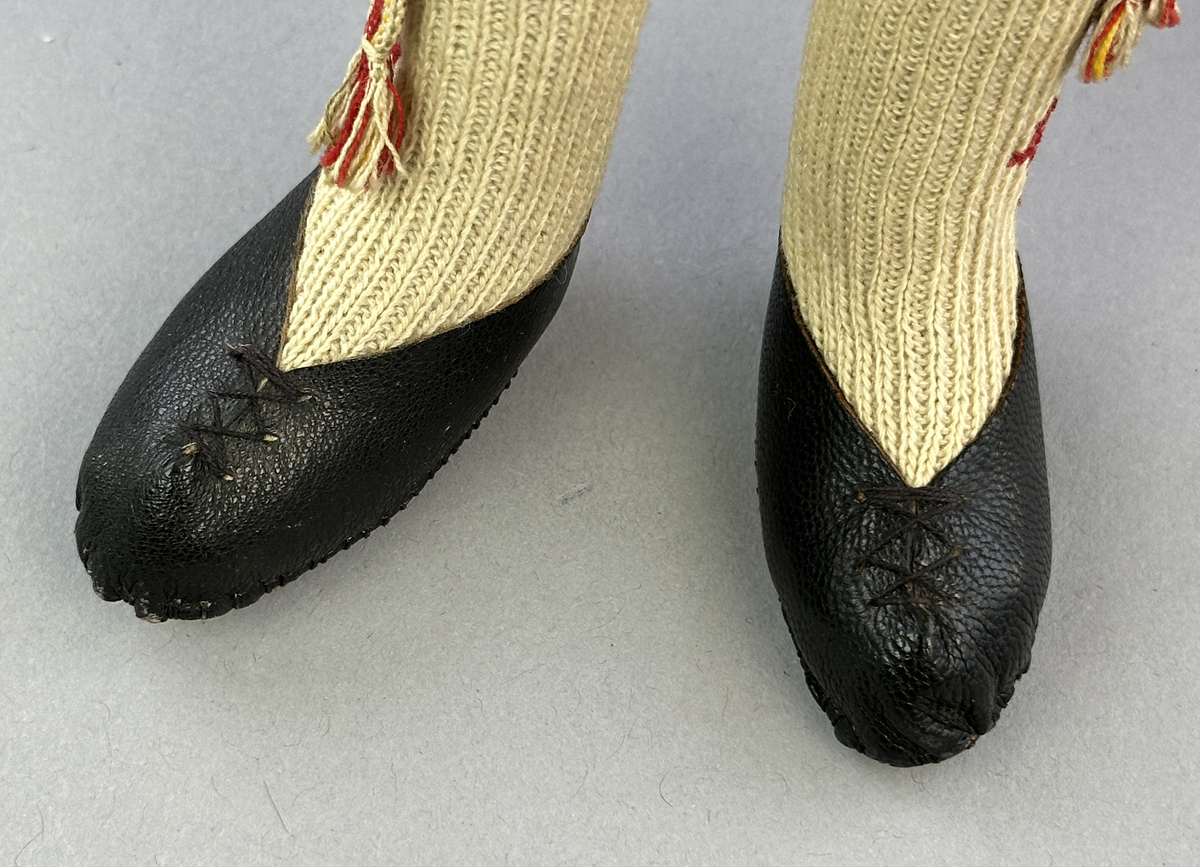 Docka klädd i manlig sockendräkt föreställande Norra Ny socken i Värmland. Huvud och händer sydda av sämskskinn samt kropp av trikåtyg.