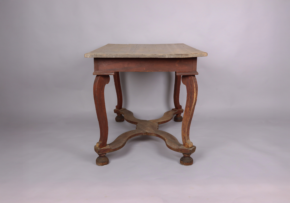 Bord av trä. Trären bordsskiva. 4 svängda ben. Varje ben avslutas med ett halvt svarvat klot. Svängd krysslå sammanför benen i nederkant. Rester av rödbrun färg på underredet.