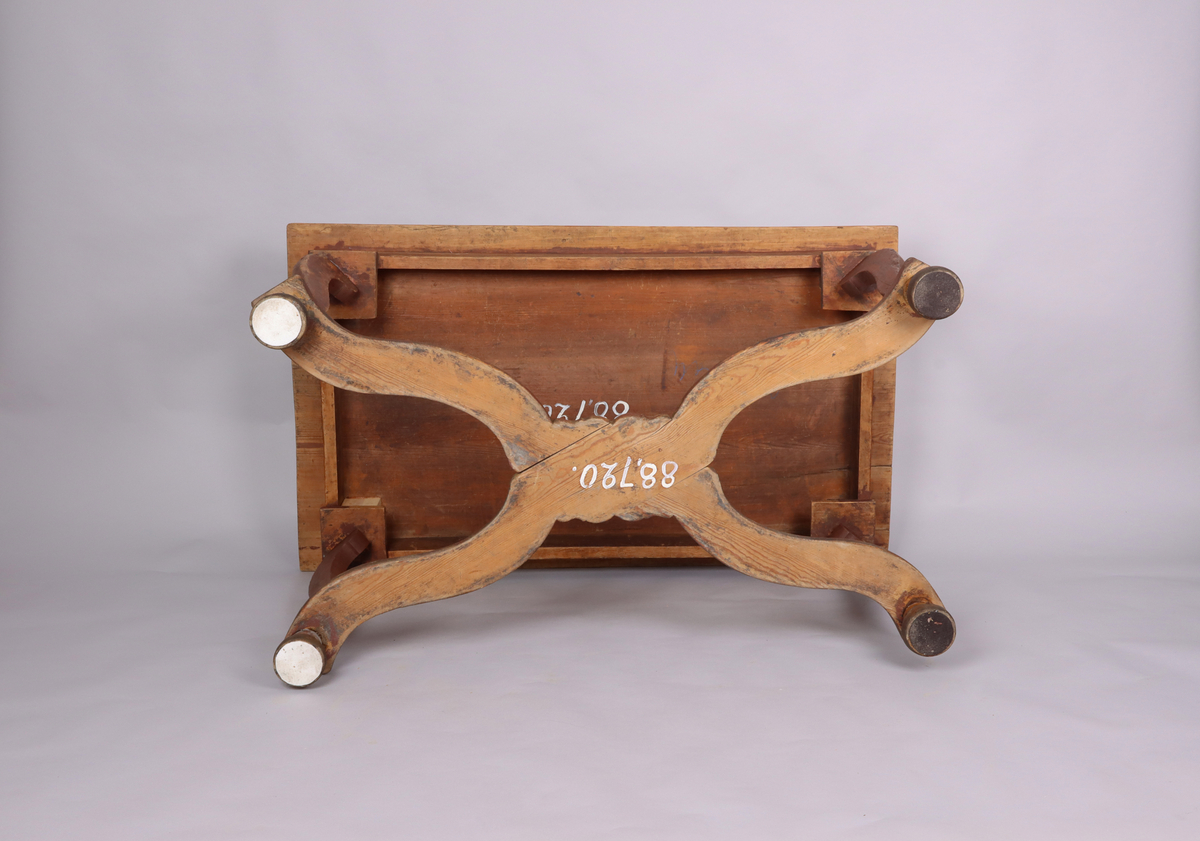 Bord av trä. Trären bordsskiva. 4 svängda ben. Varje ben avslutas med ett halvt svarvat klot. Svängd krysslå sammanför benen i nederkant. Rester av rödbrun färg på underredet.