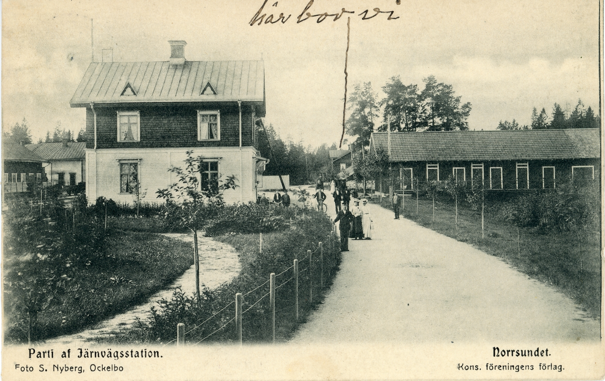 Brevkort adresserat till sjuksköterskan Amanda Palm. Motiv av parti av järnvägsstation i Norrsundet. Text på framsidan: "här bor vi"och en pil mot ett hustak. Foto S. Nyberg, Ockelbo.
Text på baksidan: "Jag kommer ihåg den 7 mars i fjol kom jag hit till Sst? 
Vi mår godt, jag kommer troligt hit och hälsar på snart. Hälsa Sörboms hälsa Elin, om hon är kvar, Putte ...? G. Åkerlund".