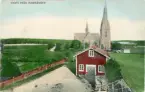 Brevkort adresserat till sjuksköterskan Amanda Palm 1907.
Motiv av parti från Harmånger med kyrka i bakgrunden och ett hus längst fram.
Text på baksidan: 