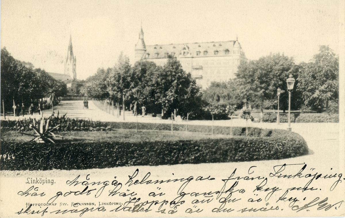 Brevkort adresserat till sjuksköterskan Amanda Palm.
Motiv av Linköping med en kyrka och annan stor byggnad i bakgrunden samt mycket grönskande träd.
Text på framsidan: "Många helsningar från Linköping. Mår godt, här är ganska kry nu. Hoppas att du är kry. Skrif några rader så är du snäll. A.W".