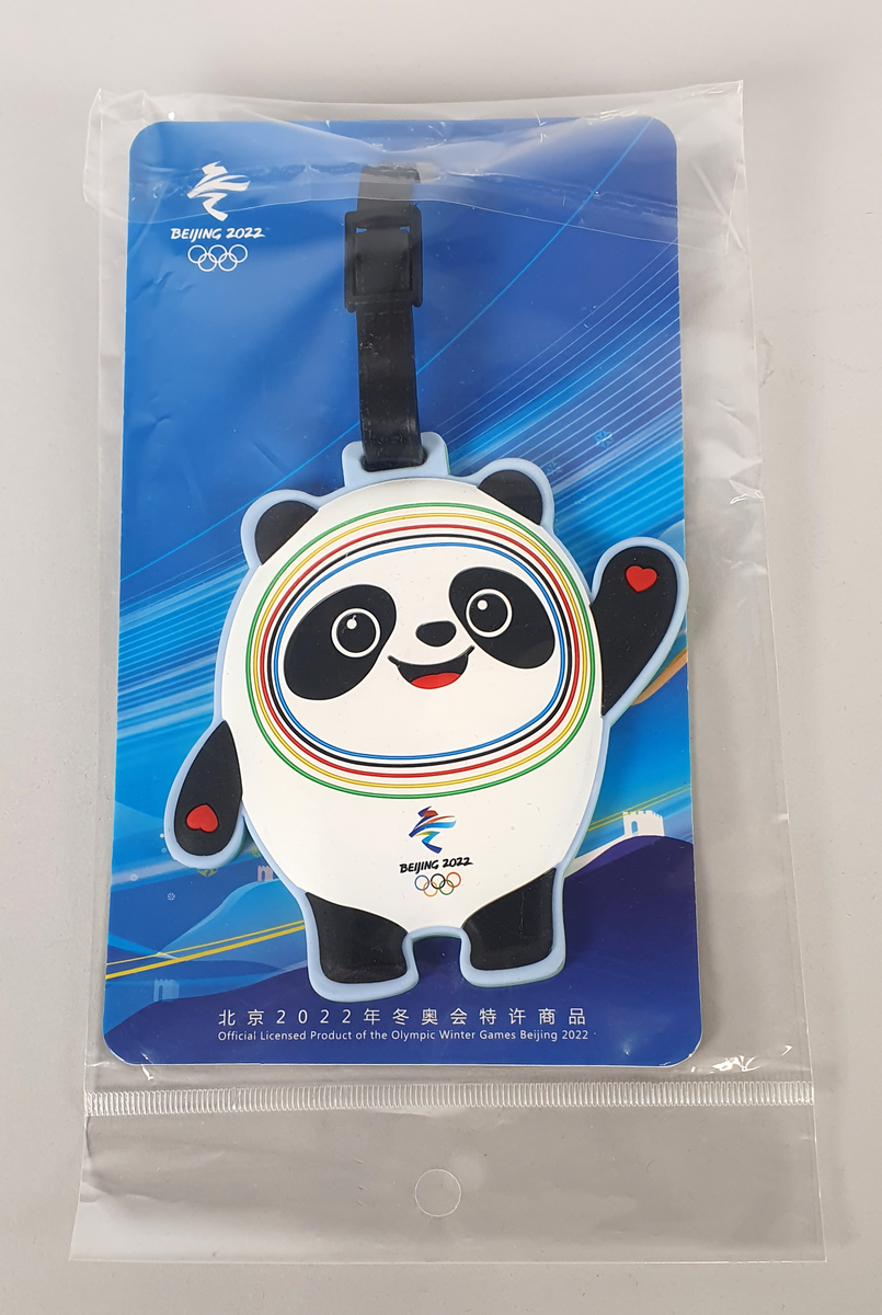 Bagasjemerke i original emballasje med maskot fra vinter-OL i Beijing 2022, med emblem midt foran.